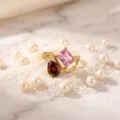 Detail shot of a gold-plated double stone ring featuring pink and red gemstones on pearls - Birthstone - October