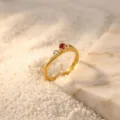 Close-up detail of minimalist two-stone ring on sand and marble background, elegant jewelry. - Size 6 / Red Round Rhinestone / Gold