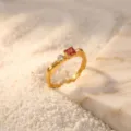 Close-up detail of the minimal gold ring adorned with a square red gem and clear diamond. - Size 6 / Red Square Gemstone / Gold
