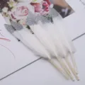Basteln weiße Federn mit glänzenden silbernen Glitzer-Spitzen, dekoratives DIY-Handwerk. - Weiße Federn mit silbernen Glitzerspitzen