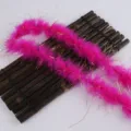 Boa en plumes rose vif avec des guirlandes dorées, accessoire de costume vibrant et emballage. - Rose rouge