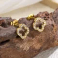 Nahaufnahme Detailansicht vergoldeter Kleeblatt Ohrstecker mit glitzernden Zirkoniasteinen. - Klee Weißer Strass Ohrstecker (5816) / Gold