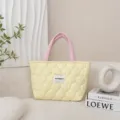 Detailed close-up of the quilted tote bag showcasing soft fabric and delicate stitching texture. - Quilted Gourd Style / Quilted Yellow Body Pink Handle