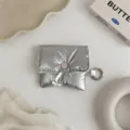 Λεπτομερής εικόνα ασημί θήκης ακουστικών με γυαλιστερό ύφασμα και κουμπί πίεσης. - 8*8cm / Ασημί