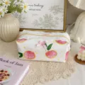 Close-up detail of cute floral cosmetic pouch with white lace trim and pink bow accent. - L / Orange Print