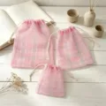 Nahaufnahme von rosa karierten Organza-Kordelzügen, transparenten Mesh-Geschenkbeuteln. - S / Hellrosa Karo