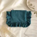 Corduroy cosmetic bag detail showing dark green fabric texture, zipper, and ruffled design. - Dark Green