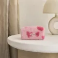 Gedetailleerde close-up van een roze pluche make-uptas met hartjesmotief op een witte tafel. - Lichtroze Harten Medium