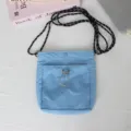 Nahaufnahme einer hellblauen Nylon-Mini-Umhaengetasche mit schwarz-weissem Seilriemen. - 15*4*18.5cm / Seeblau