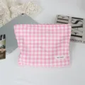Primo piano della pochette cosmetica a quadretti rosa e bianchi con etichetta. - 27*5*18cm / Quadri Rosa