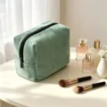 Vista de cerca del neceser de pana verde, con tela suave y cremallera práctica. - 18x9x13cm / Verde Hierba