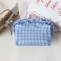 Nahaufnahme der blau-weißen Vichy-Karos Kosmetiktasche mit niedlichem Rüschenrand. - Marineblau Kariert