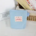 Detail view of a cute blue grid mini zipper coin pouch with handle and logo label. - S / Blue