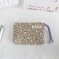Close-up detail of stylish leopard print coin purse with purple wrist strap and fabric label. - 16x11x2cm / Khaki