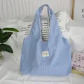Close-up of blue and white gingham tote bag, casual shoulder bag featuring a cute woven label. - 43*9*52cm / Navy Plaid