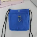 Detailaufnahme der leuchtend blauen Nylon Mini Umhängetasche mit robustem Gurt und praktischer Tasche vorn. - 15*4*18.5cm / Saphirblau