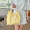 Detailansicht der gelben karierten Tasche mit rosa Schleifen, Stoffstruktur und Kordelzug. - Karomuster Gelbe Schleife