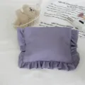 Detaillierte Ansicht der lila rüschigen Kosmetiktasche mit plissierter Textur und Stoff. - Lila