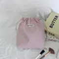 Gedetailleerd overzicht van de roze effen opbergtas met koord, zachte stof en nette naad. - Roze
