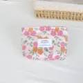 Close-up detail of the retro floral cosmetic pouch featuring jacquard fabric and sewn label. - Lipstick Pouch / Orange Pink Small Flower