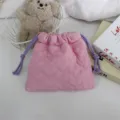 Gros plan du sac cordon matelassé rose, texture douce rembourrée avec cordons violets. - 18*16cm / Rose