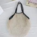Detailansicht der beigen Netztasche mit schwarzen Griffen, Strandtasche mit grossem Volumen. - Große Umhängetasche / Schwarz