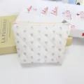 Close-up of quilted cosmetic pouch with floral pattern, cute zipper storage bag detail shot - Little Floral / White Base Floral