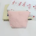 Close-up of pink quilted cosmetic pouch with cute embossed bows and secure zipper closure. - Light Pink Bow Embossed