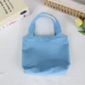 Detail view of the solid blue nylon mini tote bag, showcasing lightweight design. - 21*6*27cm / Lake Blue