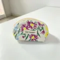 Close-up detail of the floral canvas cosmetic pouch showing delicate print and sturdy zipper. - Spring Garden Floral