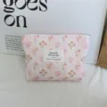Detailed close-up of a pink corduroy floral makeup bag with a cute label for daily use. - Pink Grid Floral Lipstick Bag