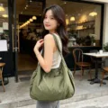Vista di dettaglio della borsa a tracolla casual leggera con cinghia regolabile e grande capienza. - Verde Scuro