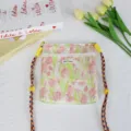 Nahaufnahme der floralen Canvas-Umhängetasche mit Hasenmuster und edler Spitzenborte. - Hase Tulpe Gelb Grün