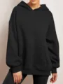 Detailed view of the solid color oversized hoodie featuring a cozy hood and front pocket. - S / Black