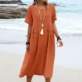 Detail view of the casual cotton linen midi dress on beach, loose fit with pockets. - S / Orange