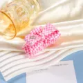 Nahaufnahme Detail der rosa karierten Schleifen Haarklammer mit Kristallherz Dekoration. - Rosa