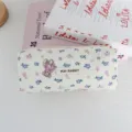 Close-up detail of cute pleated foam pencil pouch featuring floral bear print and cloth label. - Purple Floral Bear