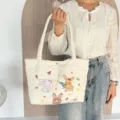 Gedetailleerd uitzicht op de schattige gewatteerde tas met konijnenpatronen en harttextuur. - Wit (Drie Kleine Konijntjes)