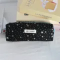 Gedetailleerd overzicht van een zwarte etui met sprankelende zilveren sterren en schattig label. - Zwart