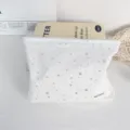 White cosmetic bag featuring silver stars pattern and compact detail design for storage. - Makeup Bag / White