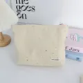 Detailed view of beige cosmetic bag with silver glitter stars, portable makeup storage pouch. - Makeup Bag / Yellow