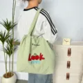 Bolso tote de lona verde casual con bonito bordado de cerezas y cómodo cierre de cordón. - Look Cereza Verde Guisante