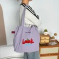 Vista detallada del bolso tote de lona morada con bordado de cerezas y cordón ajustable. - Look Cereza Morado