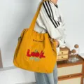 Vista detallada del bolso tote de lona amarilla, bonito diseño de cerezas con cordón. - Look Cereza Cúrcuma
