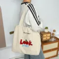 Vista detallada del bolso tote de lona con bonito bordado de cerezas y cordón ajustable. - Look Cereza Gris
