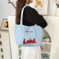 Close-up of light blue quilted heart tote bag with cute cherry embroidery and shoulder straps. - Quilted Heart Cherry Look / Blue