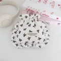 Detalle de bolsa con cordón y lazo bonita con tela de volantes y etiqueta de tela. - Blanco con lazo negro