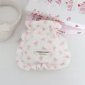 Primer plano detallado de la bonita bolsa acolchada con cordón y lazos rosados y volantes. - Blanco con lazo rosa