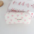 Detailed shot of white quilted pencil pouch with pink bow pattern and cute fabric label. - White with Pink Bow