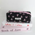 Primo piano di astuccio trapuntato nero con fiocchi rosa ed etichetta su libri decorativi. - Nero con fiocco rosa